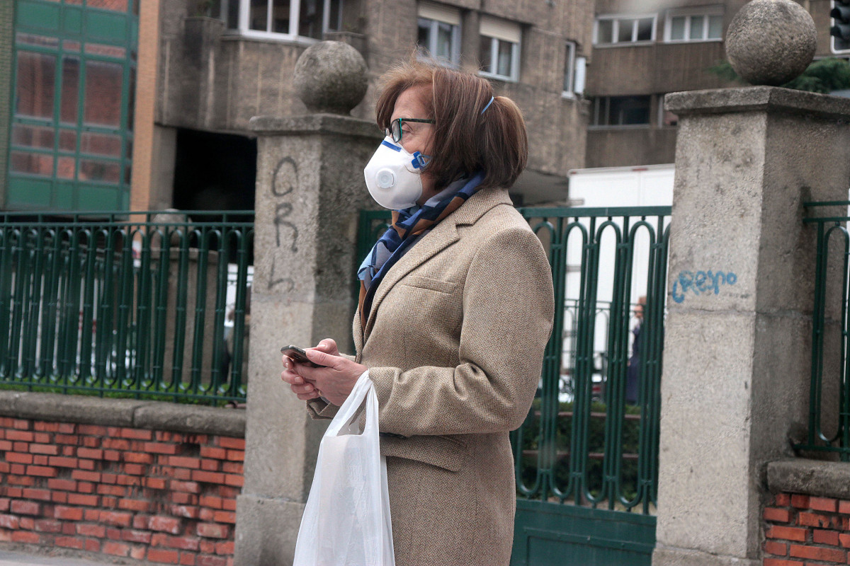 Una mujer se protege del covid con una mascarilla