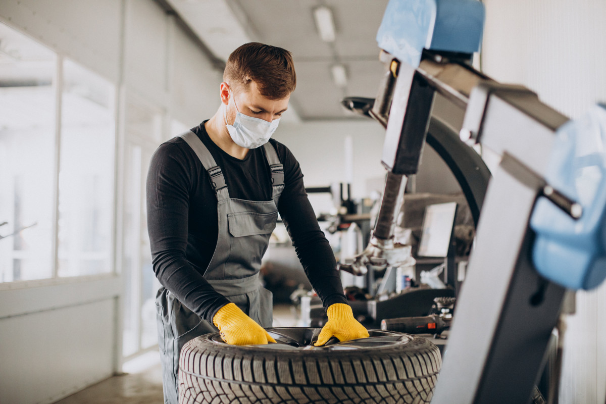 Car mechanic changing wheels in car