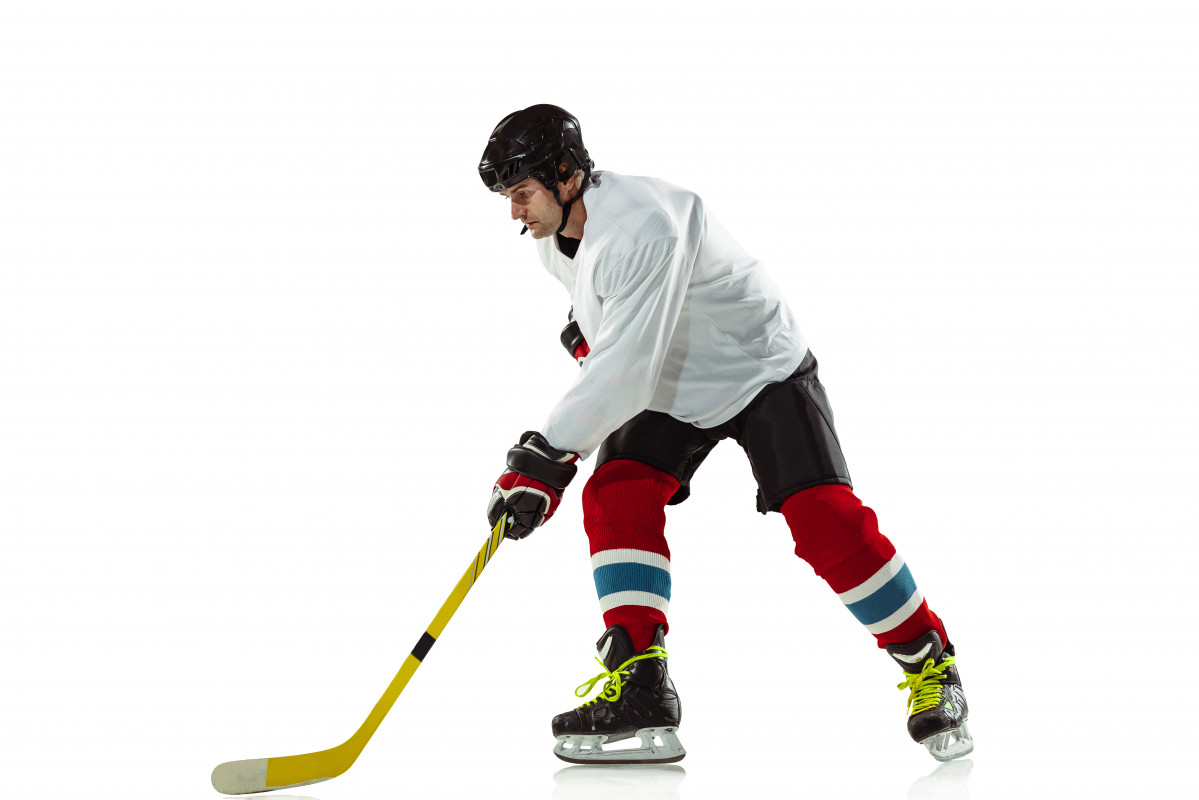 Target young male hockey player with the stick on ice court and white wall sportsman wearing equipment and helmet practicing concept of sport healthy lifestyle motion movement action