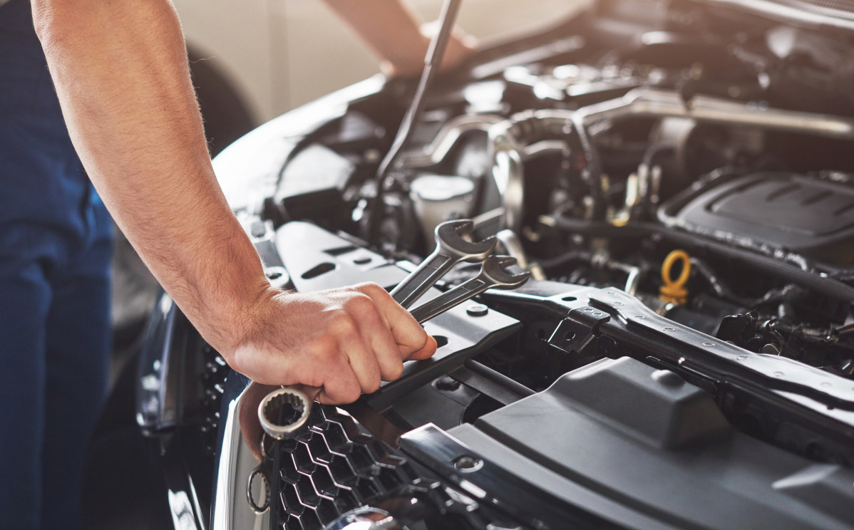Trabajador servicio coche musculoso reparando vehiculo